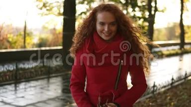 一个快乐的红头女人在秋天的日子里到处扔<strong>树叶</strong>的肖像。 秋天的<strong>树叶飘落</strong>在快乐的年轻女子身上